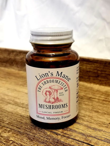 A glass bottle containing capsules labeled Lion's Mane Mushrooms, with a white and red color scheme and text indicating mood, memory, and focus support.