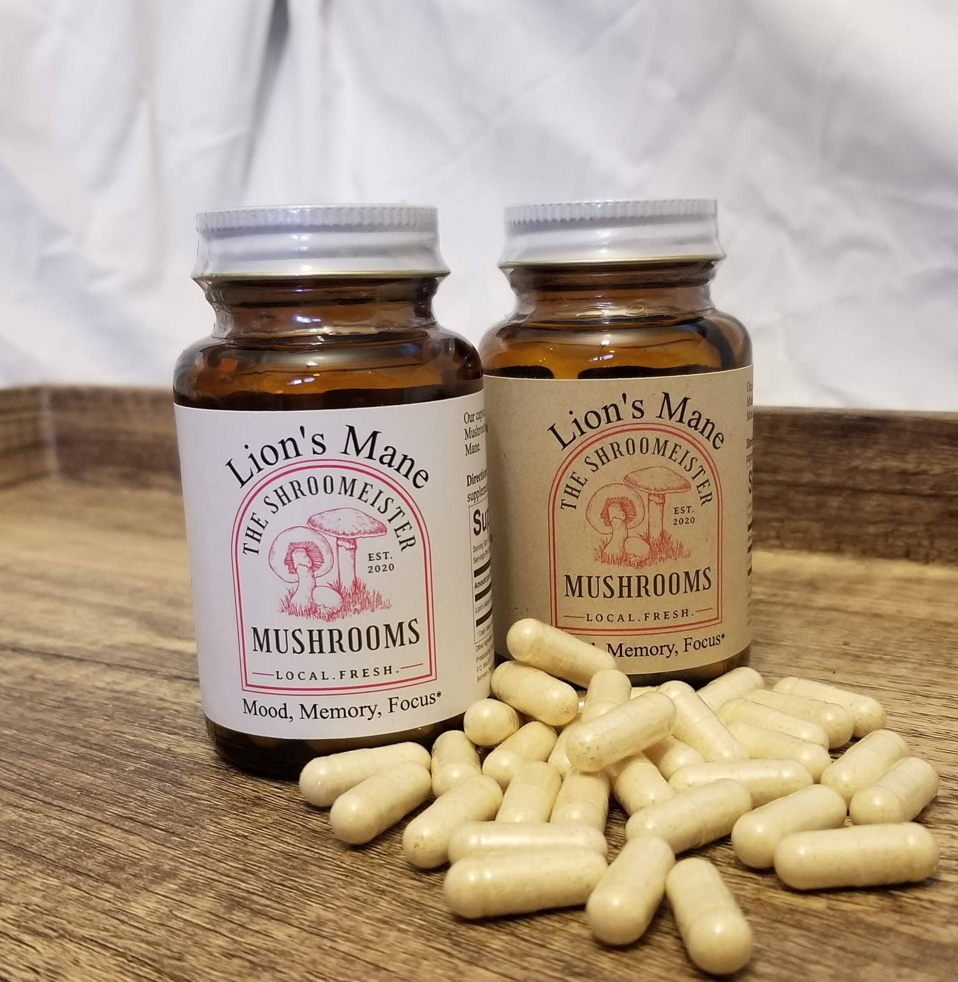 Two glass bottles containing capsules labeled Lion's Mane Mushrooms, with a beige and brown color scheme and text indicating mood, memory, and focus support and Lion's Mane capsules next to the bottles.