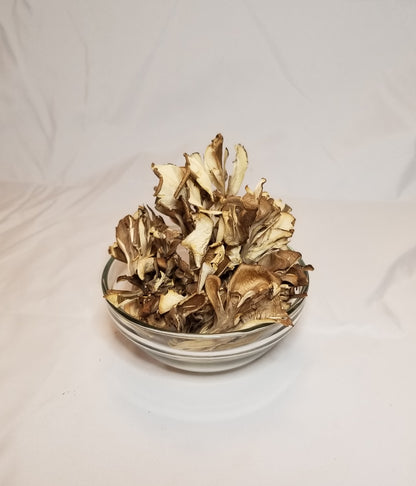 Dried Hen of The Woods in a clear glass bowl with a white background